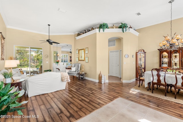 tiled living room with crown molding and ceiling fan with notable chandelier