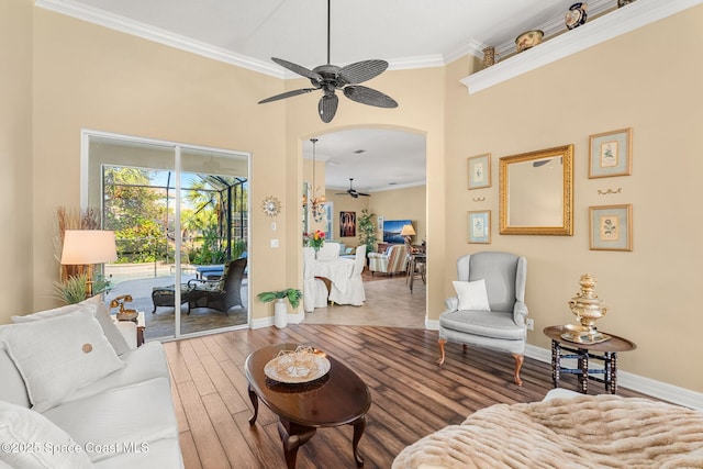 living room with hardwood / wood-style flooring, ceiling fan, and crown molding