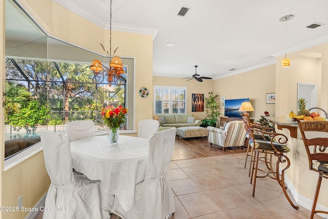 tiled dining space featuring ceiling fan with notable chandelier and crown molding