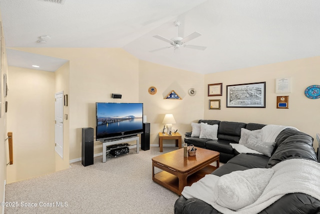 carpeted living room with ceiling fan and vaulted ceiling