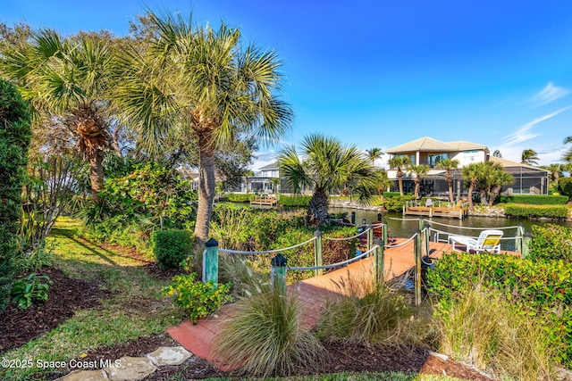 surrounding community featuring a water view and a dock