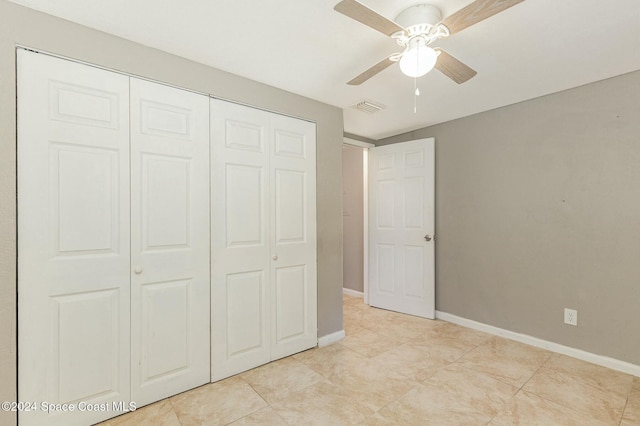 unfurnished bedroom with ceiling fan, light tile patterned floors, and a closet