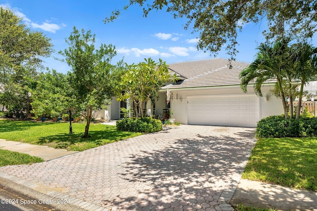 view of front of house featuring a garage and a front lawn