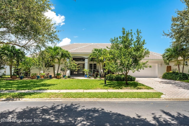 obstructed view of property with a front yard and a garage