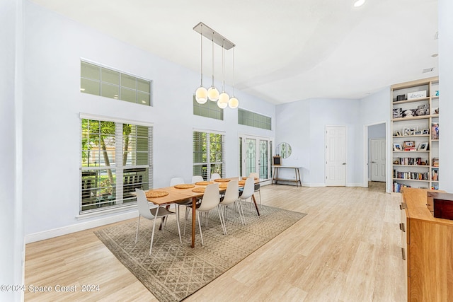 dining area with hardwood / wood-style floors and a high ceiling