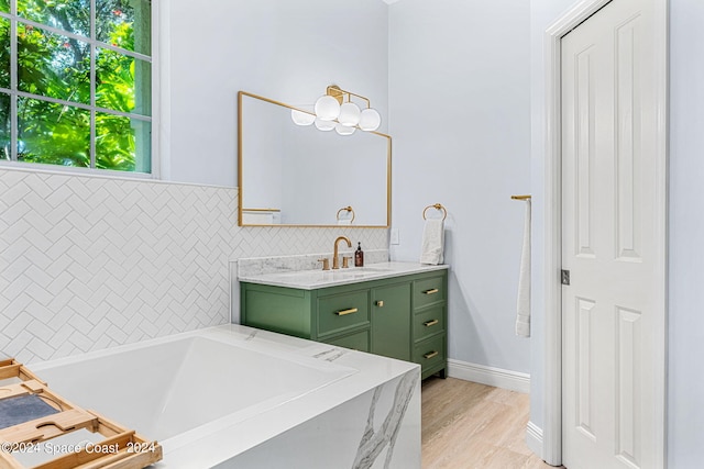 bathroom with tasteful backsplash, a tub to relax in, and vanity