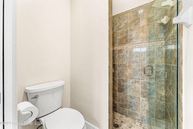 bathroom with toilet and a shower with shower door