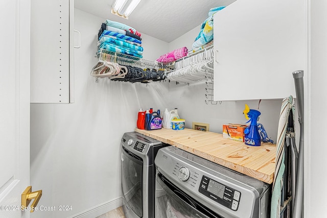 laundry room featuring washer and clothes dryer and a textured ceiling