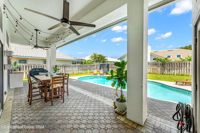 view of pool with ceiling fan, area for grilling, and a patio area