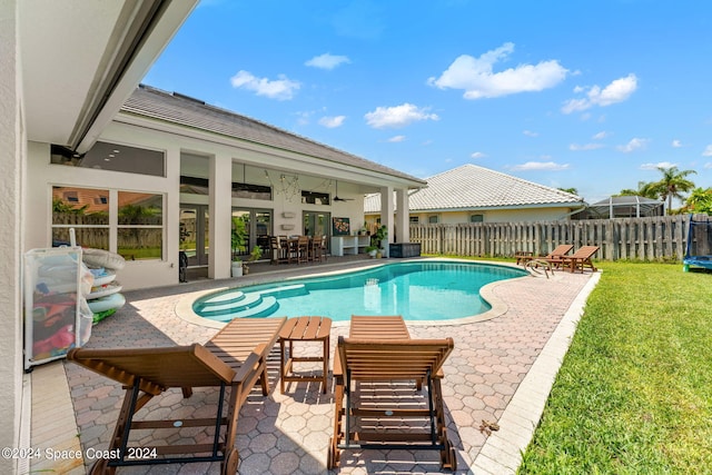 view of swimming pool with ceiling fan, a patio area, and a trampoline