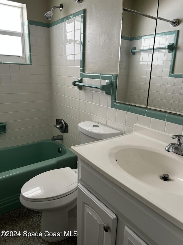 full bathroom featuring backsplash, toilet, vanity, tile walls, and tiled shower / bath