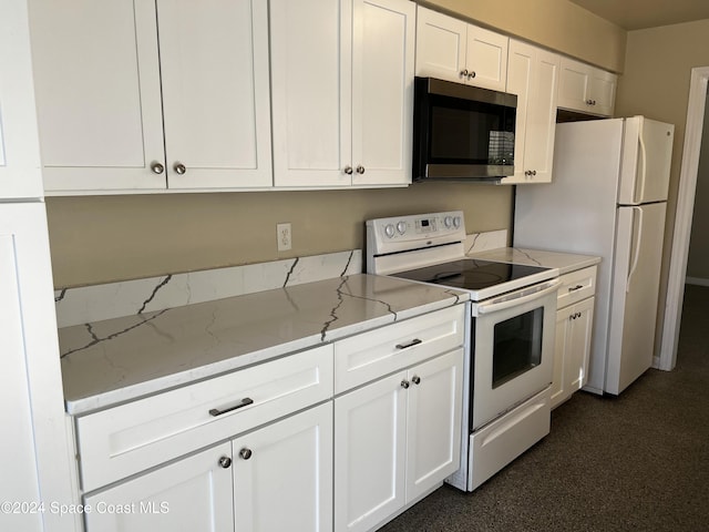 kitchen with white cabinetry, light stone counters, and white appliances