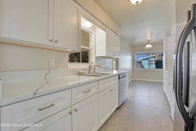 kitchen featuring white cabinets, stainless steel appliances, light stone counters, and sink