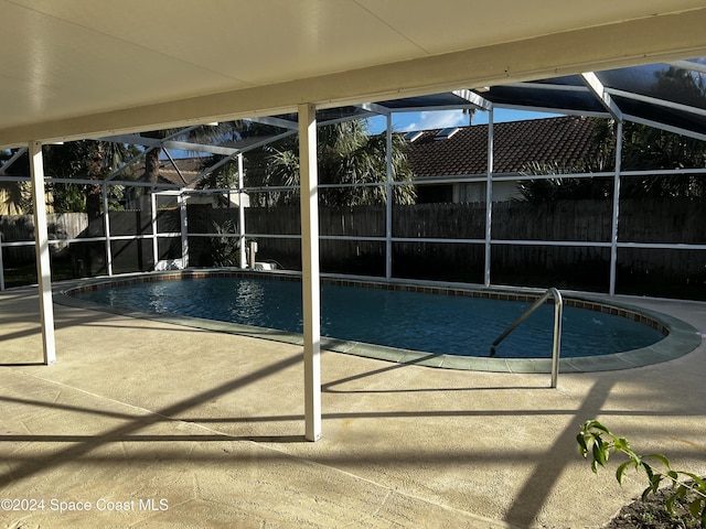 view of swimming pool with a lanai and a patio