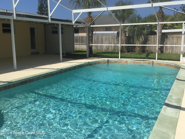 view of swimming pool with glass enclosure and a patio area