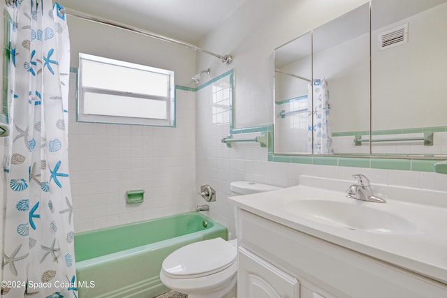 full bathroom with shower / tub combo, vanity, toilet, and tile walls