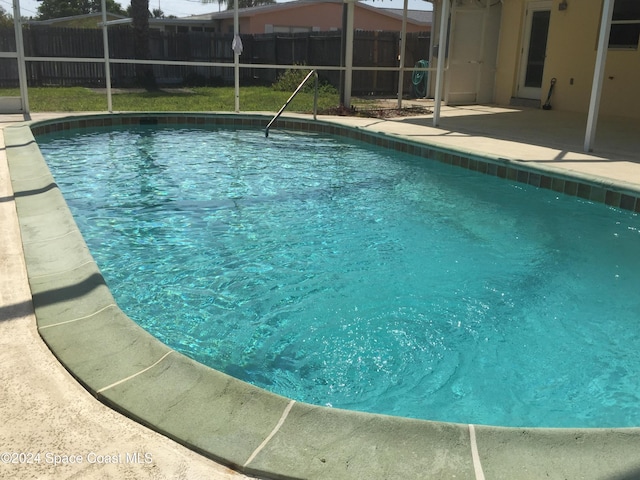 view of swimming pool with a patio area and glass enclosure