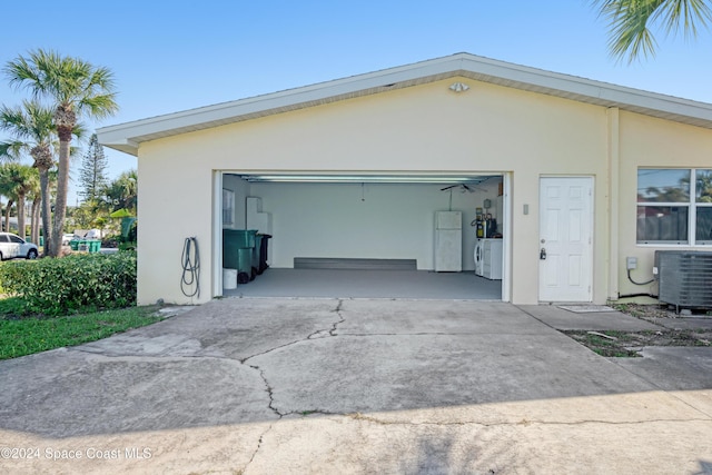 garage with independent washer and dryer and central AC unit