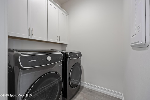 laundry room with cabinets and washing machine and clothes dryer