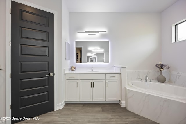 bathroom with vanity and tiled bath