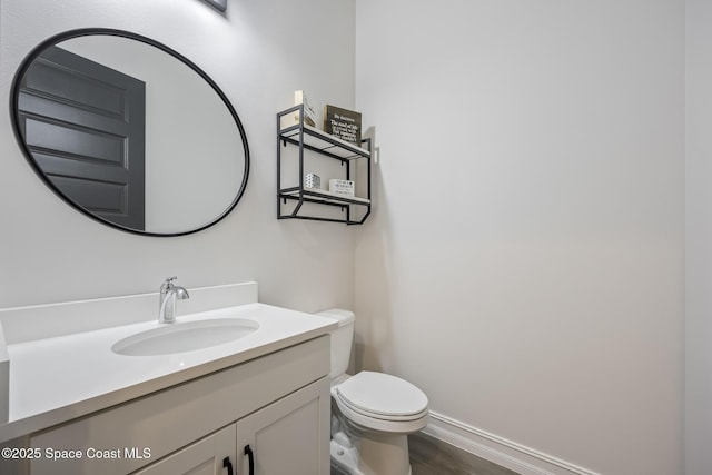 bathroom with vanity, toilet, and wood-type flooring