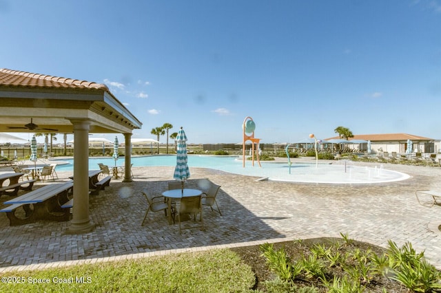 exterior space with pool water feature, a patio area, and a water view