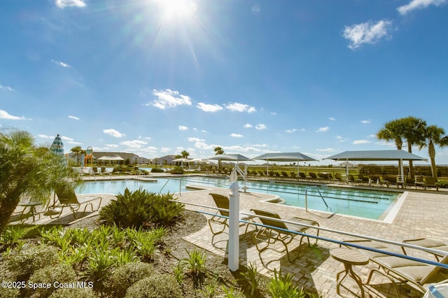 view of pool with a patio area and a water view