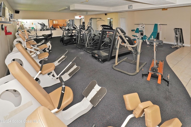 gym featuring tile patterned flooring and a textured ceiling