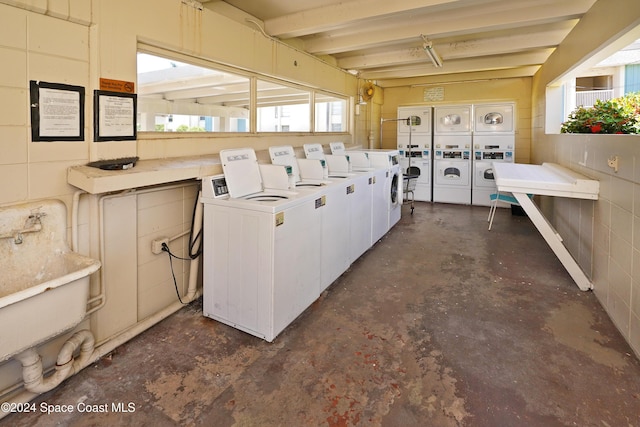 clothes washing area featuring washer and clothes dryer, stacked washer / drying machine, and sink