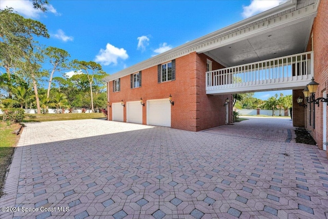 view of property exterior with a garage and a balcony