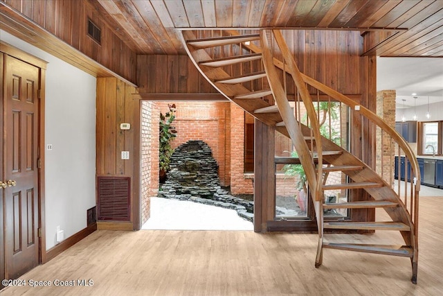 interior space with wood-type flooring, wooden walls, and wood ceiling