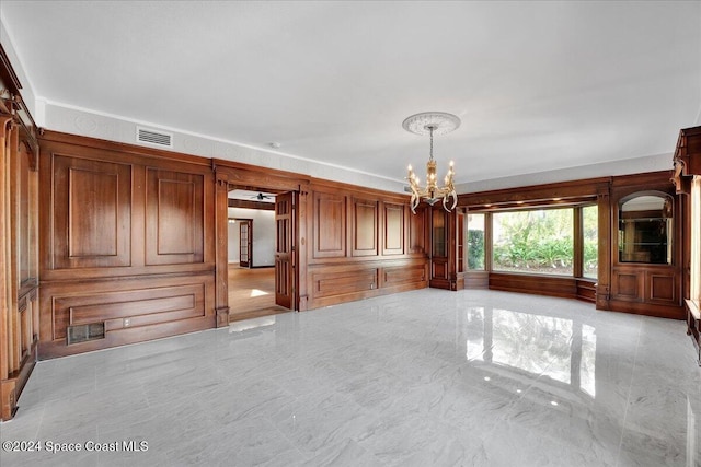 unfurnished living room featuring a chandelier