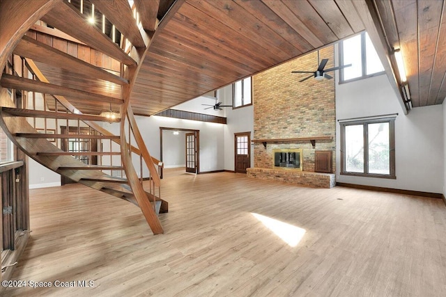 unfurnished living room with ceiling fan, a large fireplace, wooden ceiling, and high vaulted ceiling