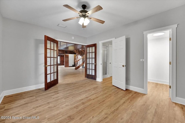 unfurnished room with french doors, light hardwood / wood-style flooring, and ceiling fan