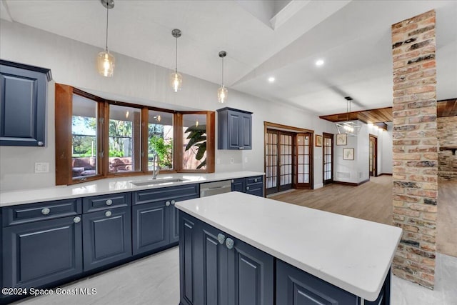 kitchen with lofted ceiling, sink, stainless steel dishwasher, blue cabinetry, and decorative light fixtures