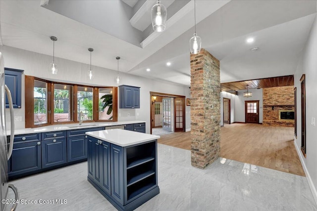 kitchen with decorative light fixtures, ornate columns, blue cabinets, and a kitchen island