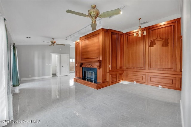 unfurnished living room featuring rail lighting and ornamental molding