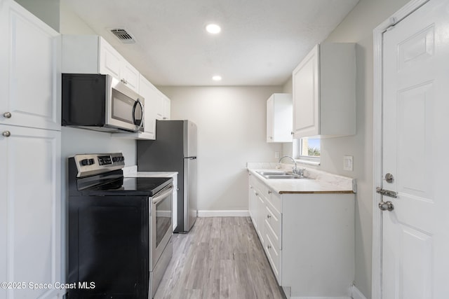 kitchen with baseboards, visible vents, a sink, stainless steel appliances, and light countertops