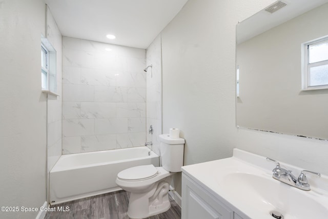 full bath featuring visible vents, toilet, wood finished floors, bathtub / shower combination, and vanity