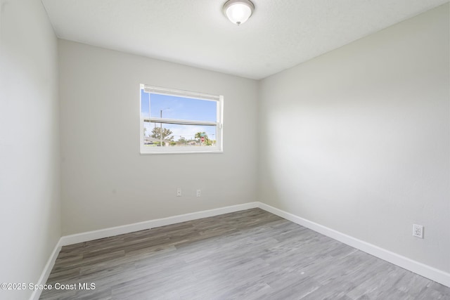 empty room featuring baseboards and wood finished floors