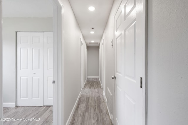 corridor with recessed lighting, baseboards, and light wood finished floors