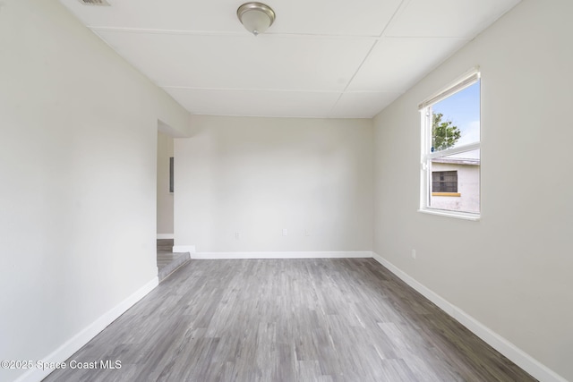 unfurnished room with baseboards and wood finished floors