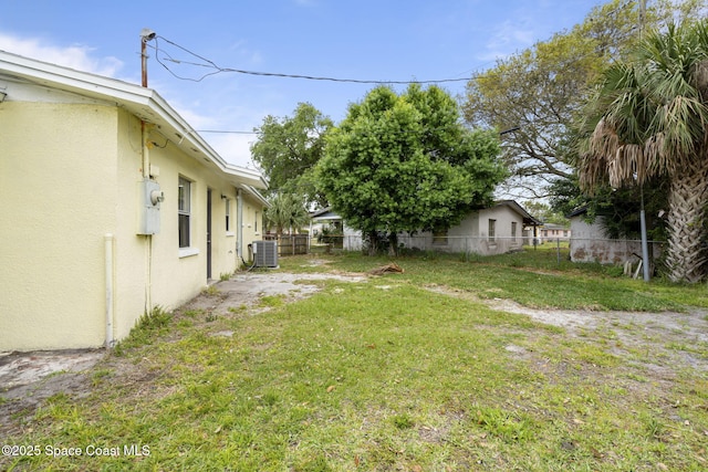 view of yard with central AC unit and fence