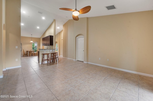 interior space featuring ceiling fan, light tile patterned floors, and high vaulted ceiling