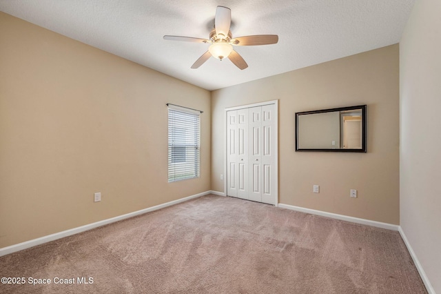 unfurnished bedroom featuring ceiling fan, light colored carpet, and a closet