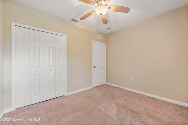 unfurnished bedroom featuring a closet, ceiling fan, and light colored carpet