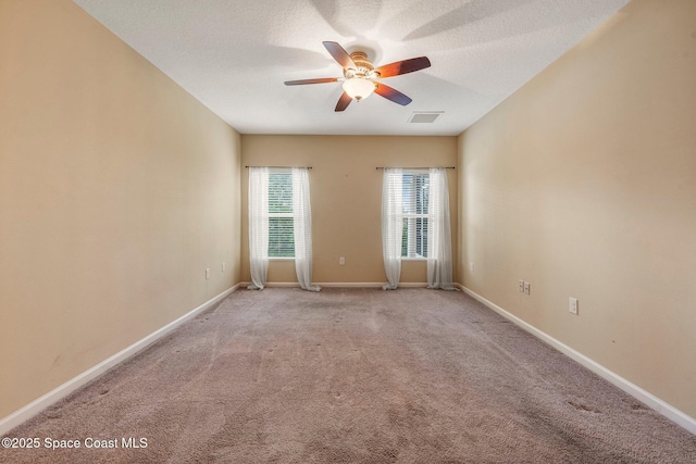 carpeted empty room featuring ceiling fan and a textured ceiling