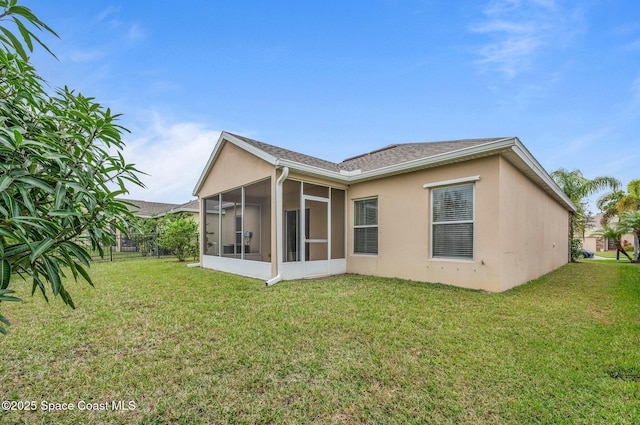 back of property with a sunroom and a yard