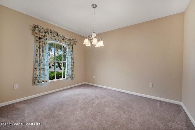 carpeted empty room featuring a notable chandelier