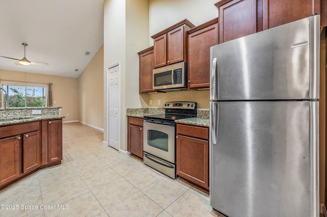 kitchen with lofted ceiling, ceiling fan, light stone countertops, light tile patterned floors, and stainless steel appliances